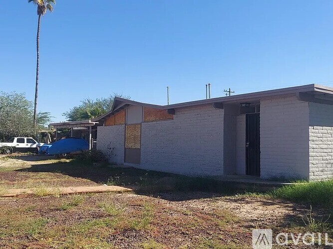 A white building with a blue tarp in front of it.