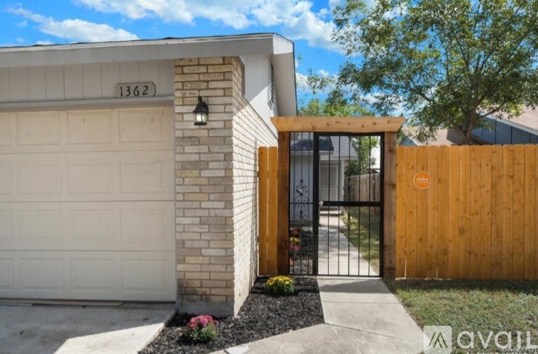 A house numbered 1362 with a wooden front door and a black gate.