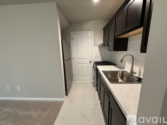 A kitchen with a sink and a door.