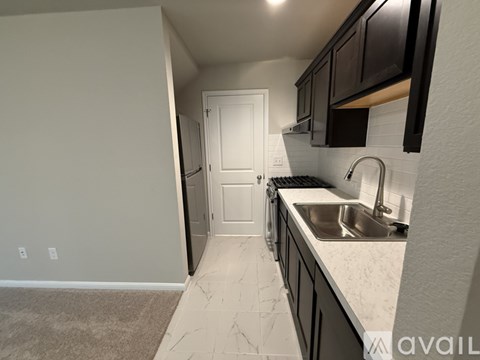 A kitchen with a sink and a door.