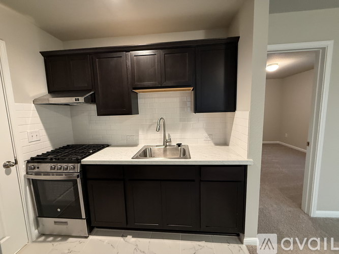 A kitchen with black cabinets and a white countertop.