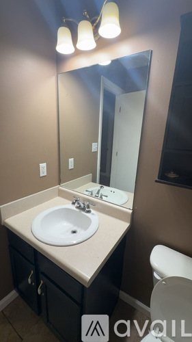 A bathroom with a sink, mirror, and toilet.