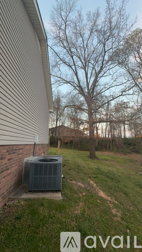A house with a tree and a grassy area in front.