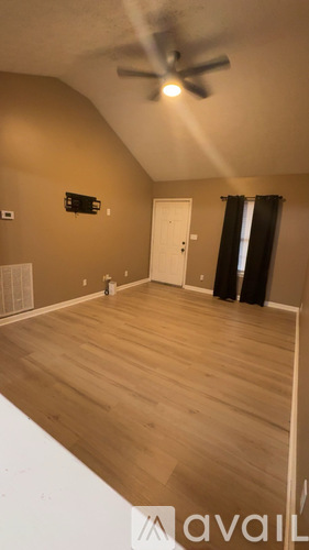 A room with a ceiling fan and wooden flooring.