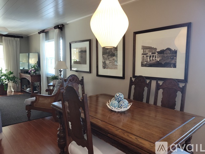 A dining room with a wooden table and chairs.