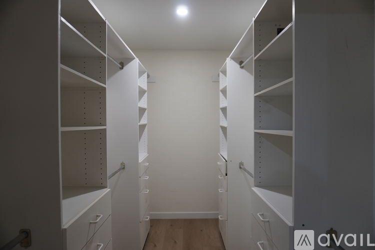 A long hallway with white shelves on the side.