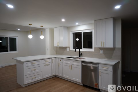 A modern kitchen with white cabinets and a stainless steel dishwasher.