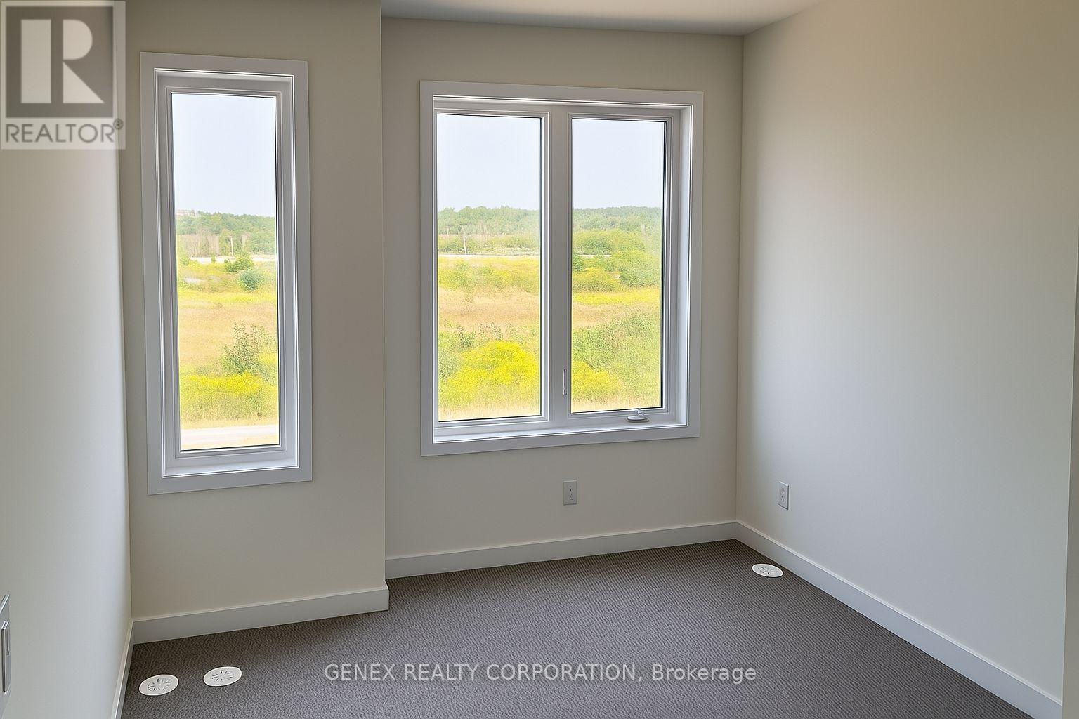 A room with two windows and a sign that says "REALTOR" on the wall.
