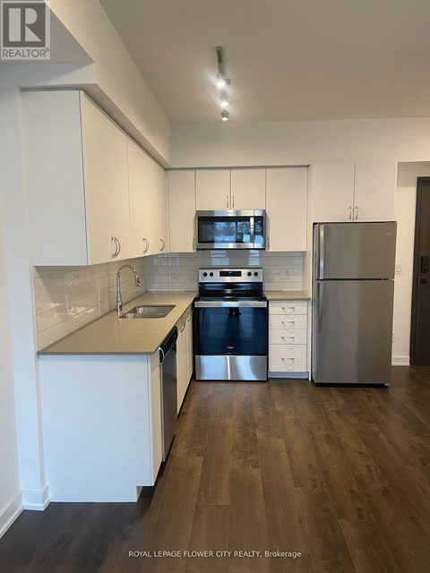 A modern kitchen with white cabinets and stainless steel appliances.