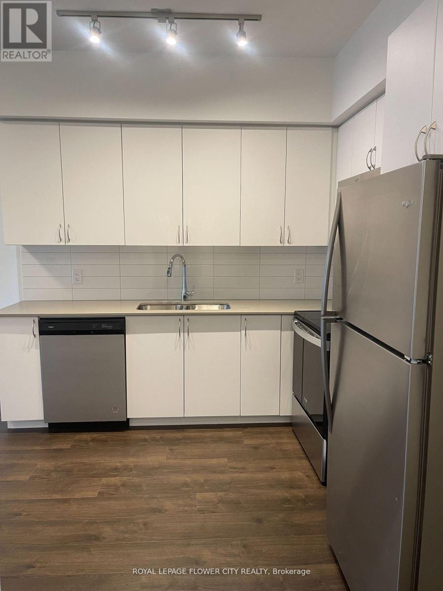A kitchen with white cabinets and a stainless steel refrigerator.