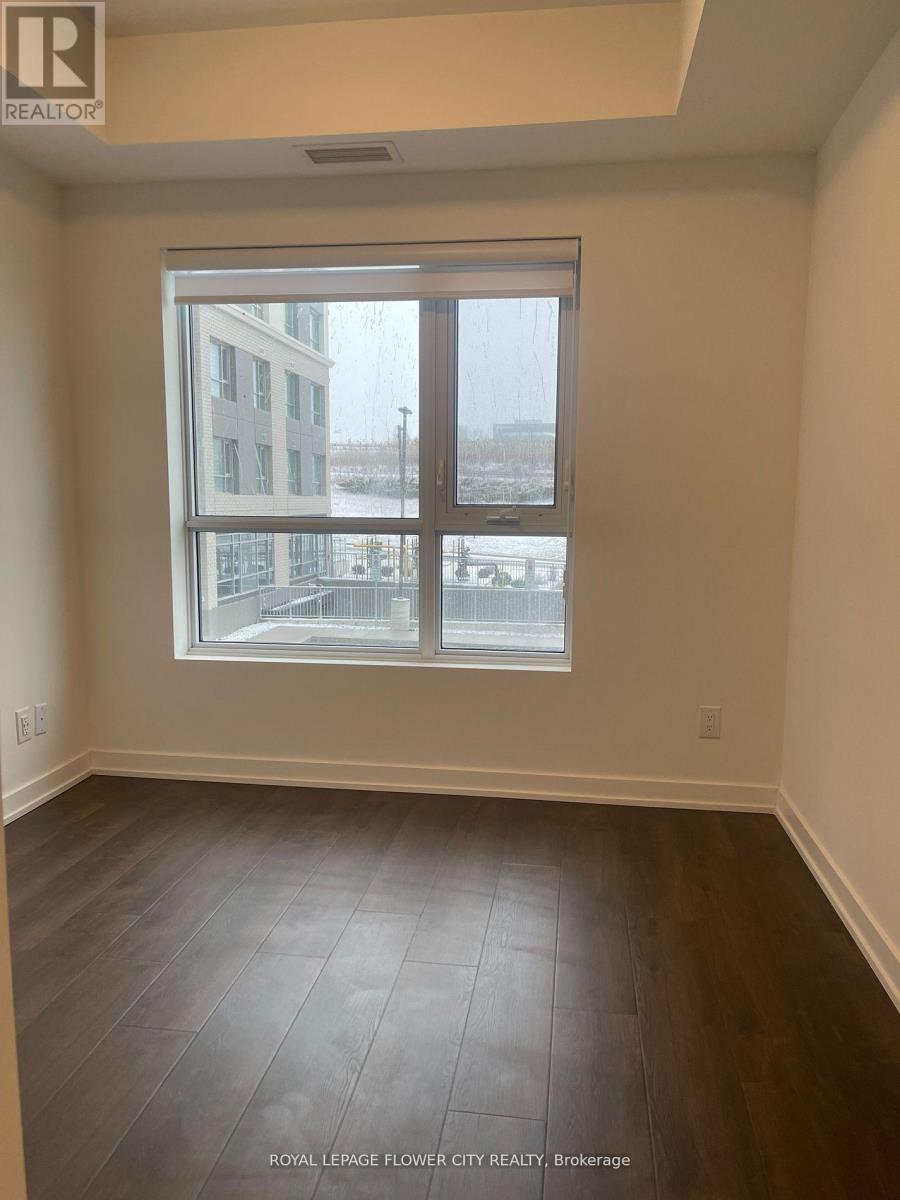 A room with a large window and wooden flooring.