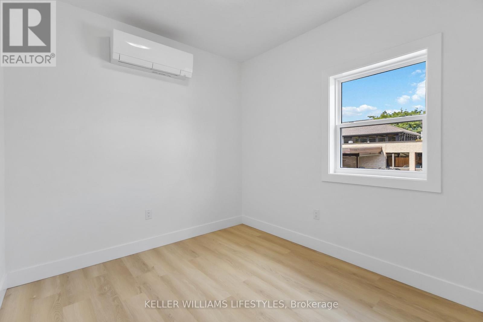 A room with a window showing a building outside.