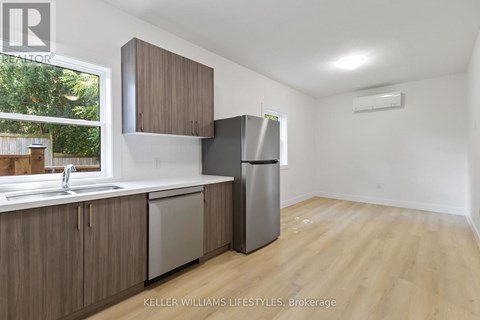 A kitchen with wooden cabinets and a stainless steel refrigerator.