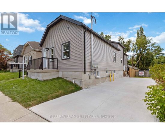 A realtor photo of a house with a driveway and a fence.