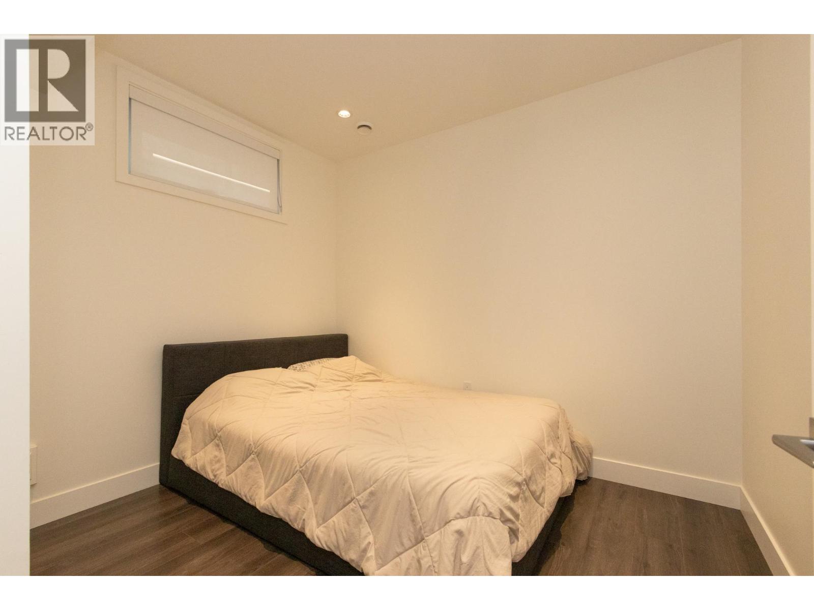 A bedroom with a bed and a window.