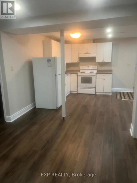 A kitchen with white appliances and wooden floors.
