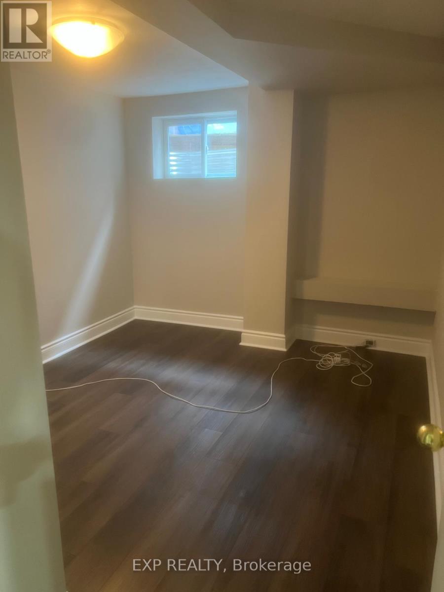 A room with a window and wooden flooring.