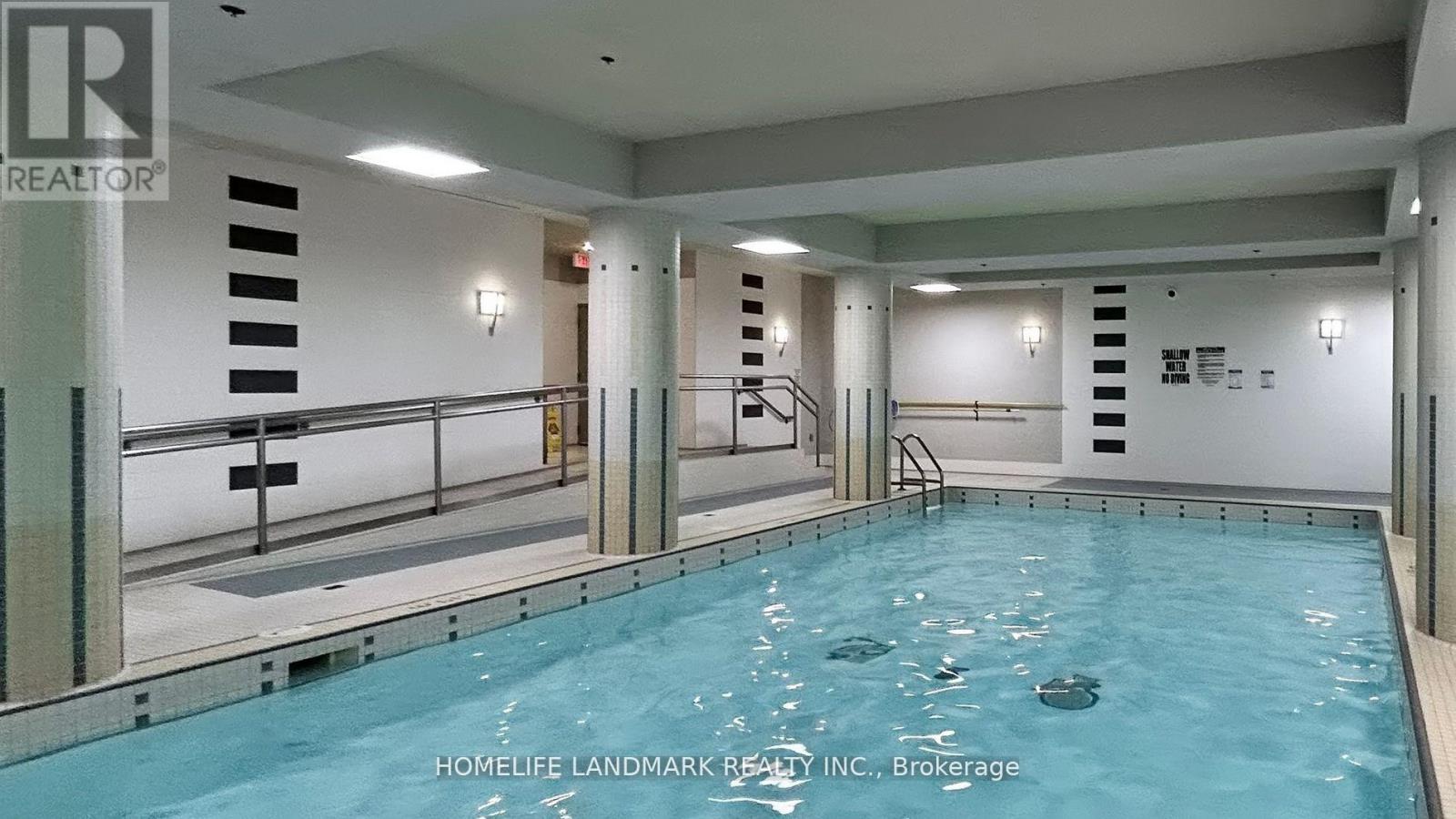 A pool inside a building with a staircase on the side.