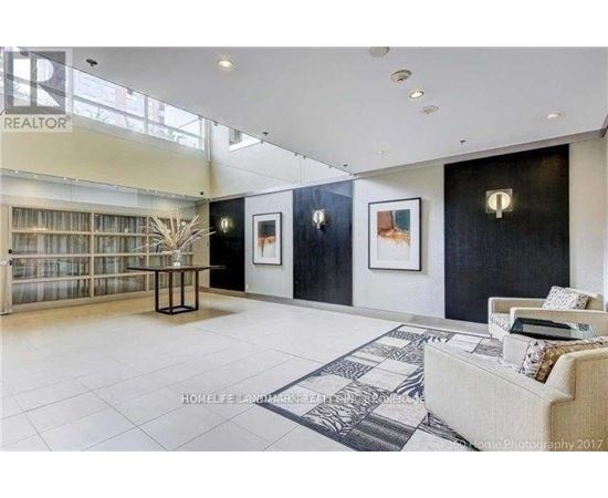 A living room with a couch, a table, and a painting on the wall.