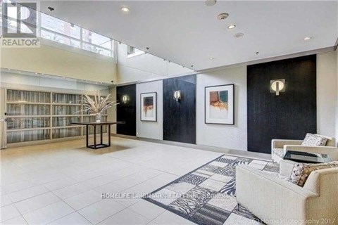 A living room with a couch, a table, and a painting on the wall.