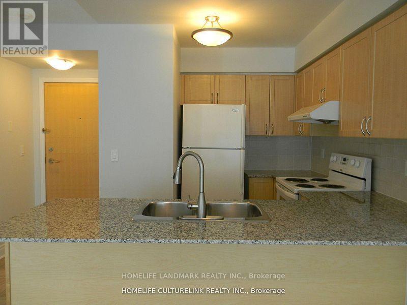 A kitchen with a sink and a refrigerator.