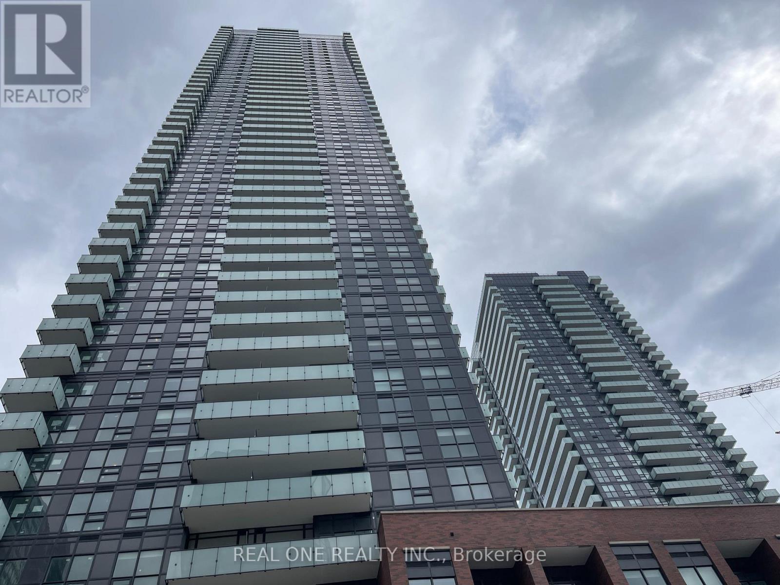 A tall building with the words "REAL ONE REALTY INC Brokerage" on the side.