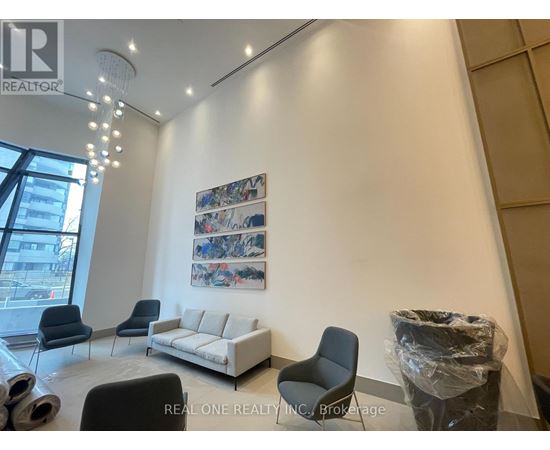 A realtor's office with a white couch, black chairs, and a large painting on the wall.