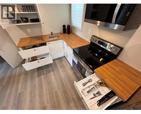 A kitchen with a black stove top oven and wooden countertops.