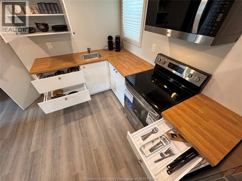 A kitchen with a black stove top oven and wooden countertops.