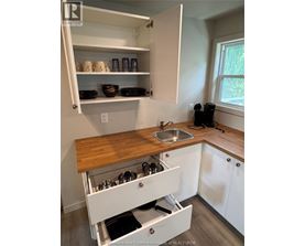 A kitchen with white cabinets and a wooden counter top.