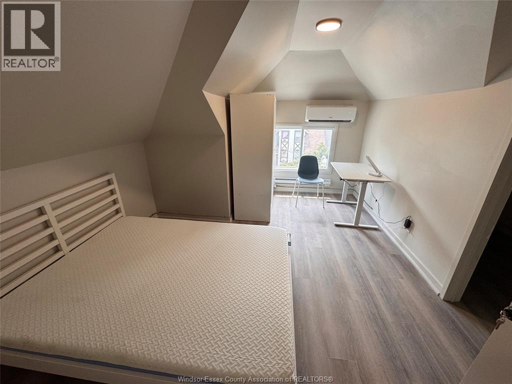 A bedroom with a bed, desk, and chair.
