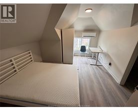A bedroom with a bed, desk, and chair.