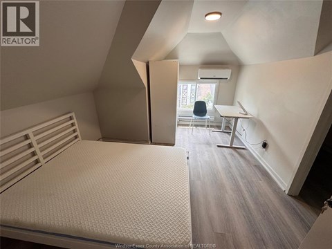 A bedroom with a bed, desk, and chair.
