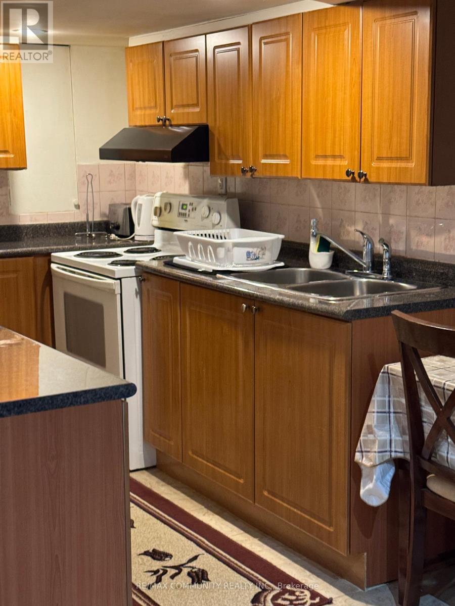 A kitchen with wooden cabinets and a black range hood.