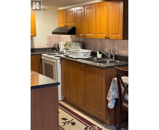A kitchen with wooden cabinets and a black range hood.