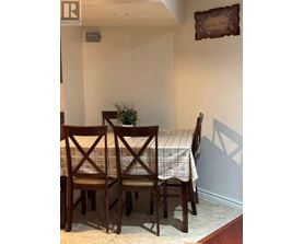 A dining room with a table and chairs.