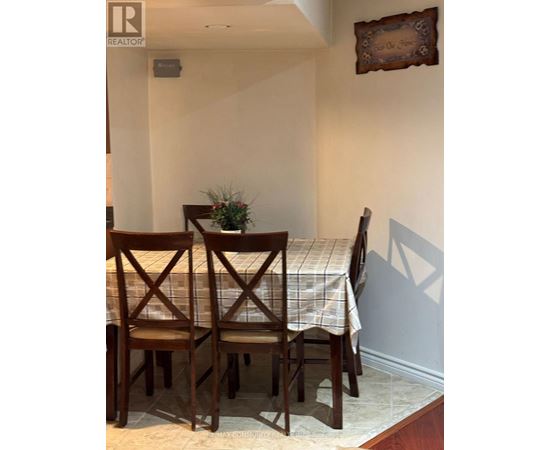 A dining room with a table and chairs.