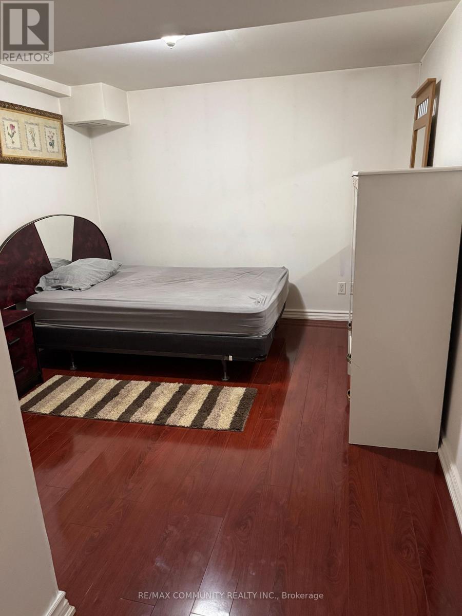 A bedroom with a bed, a chair, and a rug.