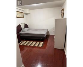 A bedroom with a bed, a chair, and a rug.