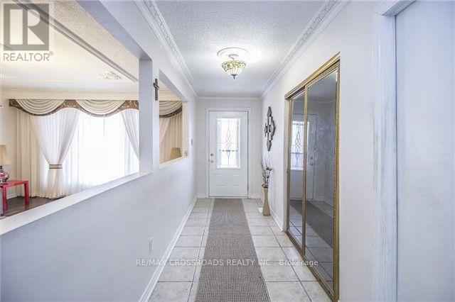 A hallway with a rug on the floor and a door at the end.