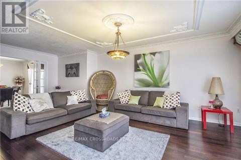A living room with a grey sofa and a round wicker chair.