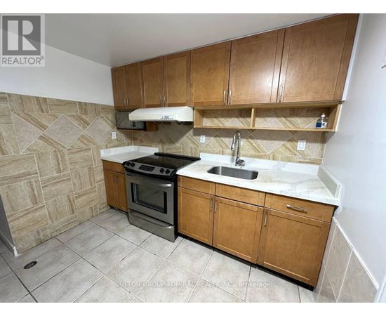 A kitchen with wooden cabinets and a tiled floor.