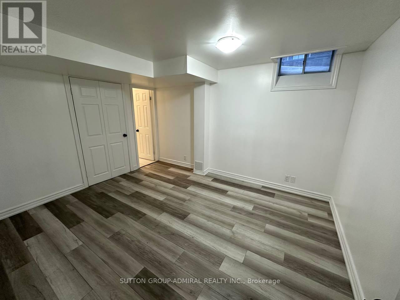 A room with wooden flooring and a window with a white frame.