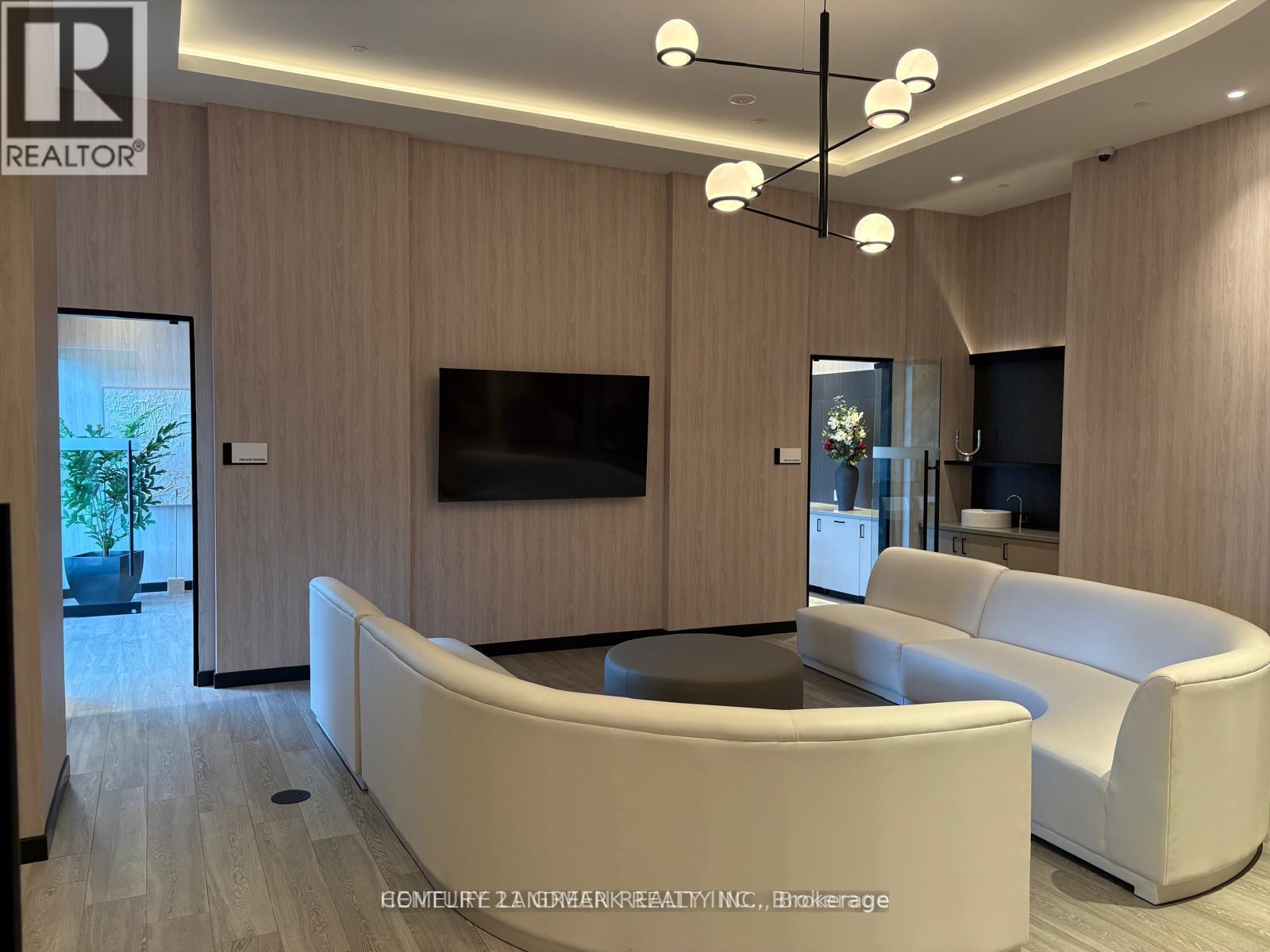 A modern living room with a flat screen TV mounted on the wall.