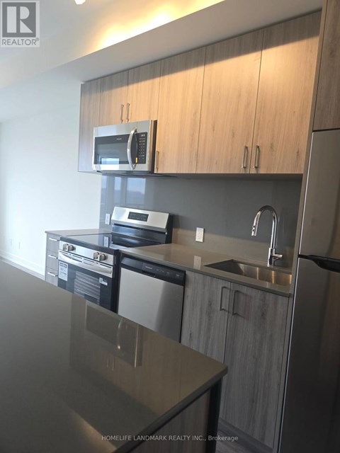A modern kitchen with a stainless steel sink and microwave.