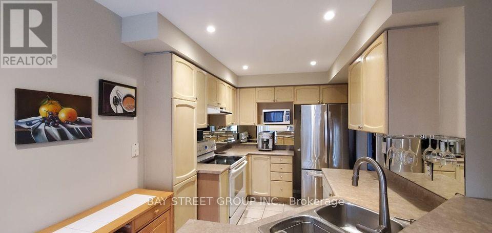 A modern kitchen with a sink, stove, and refrigerator.