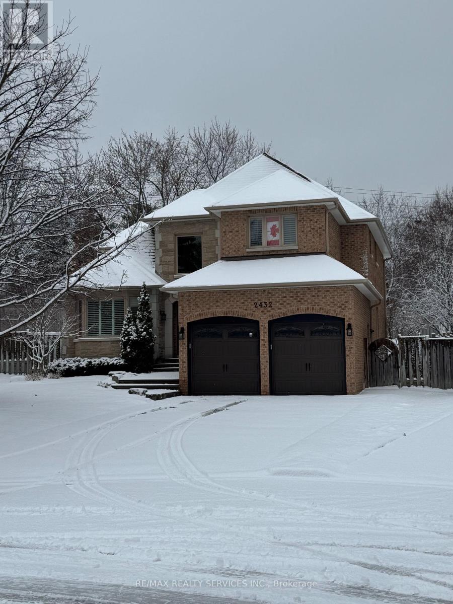 A house with a snow covered roof and garage doors.