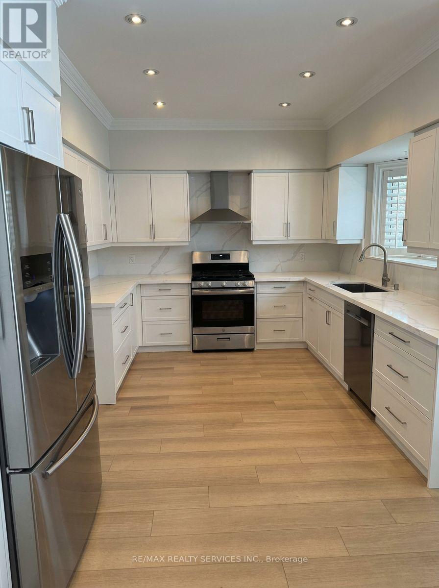 A kitchen with white cabinets and a wooden floor.