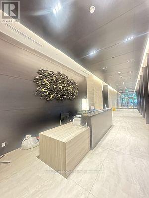 A reception area with a wooden counter and a large sculpture on the wall.