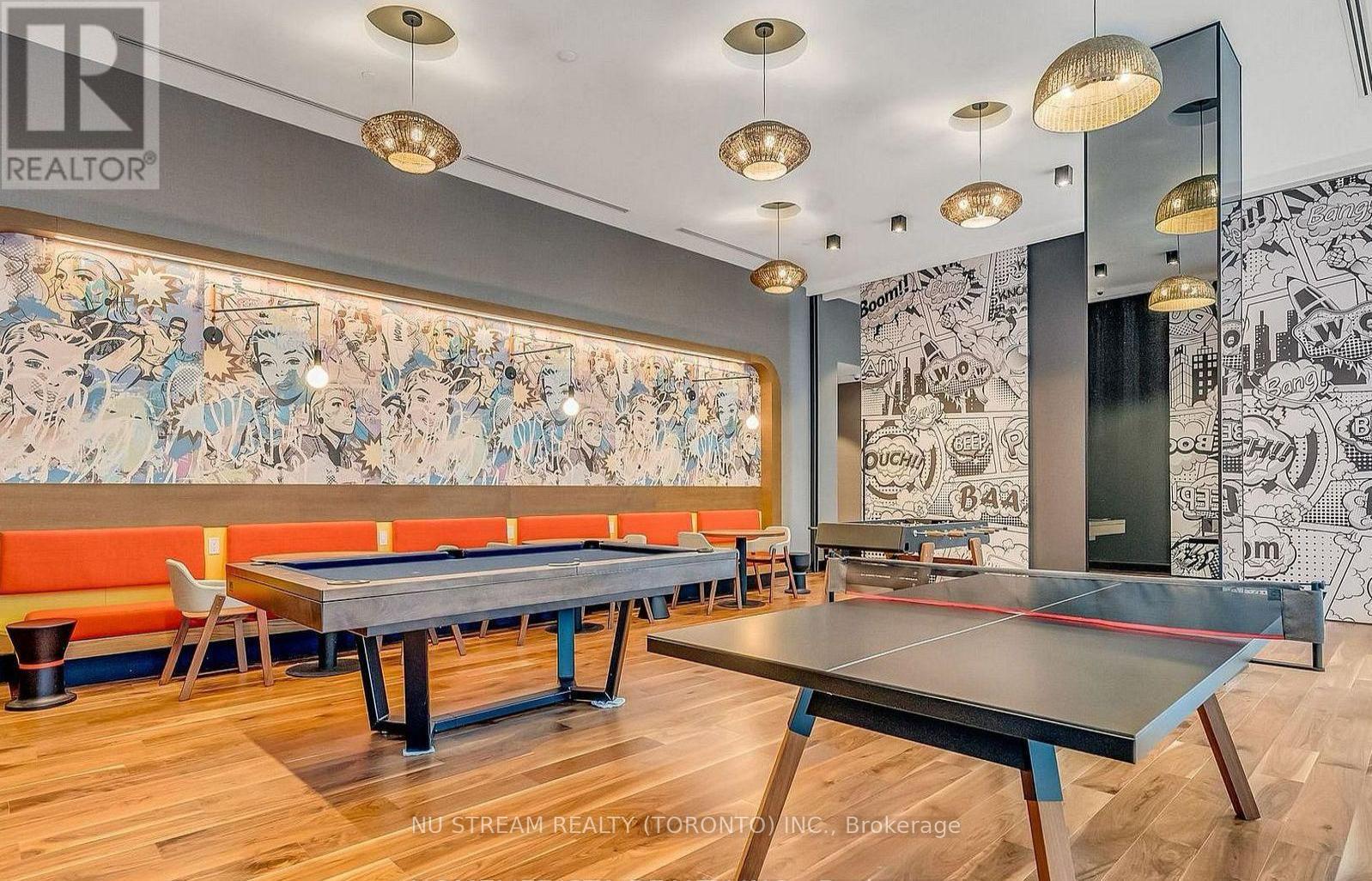 A room with a pool table and a mural on the wall.